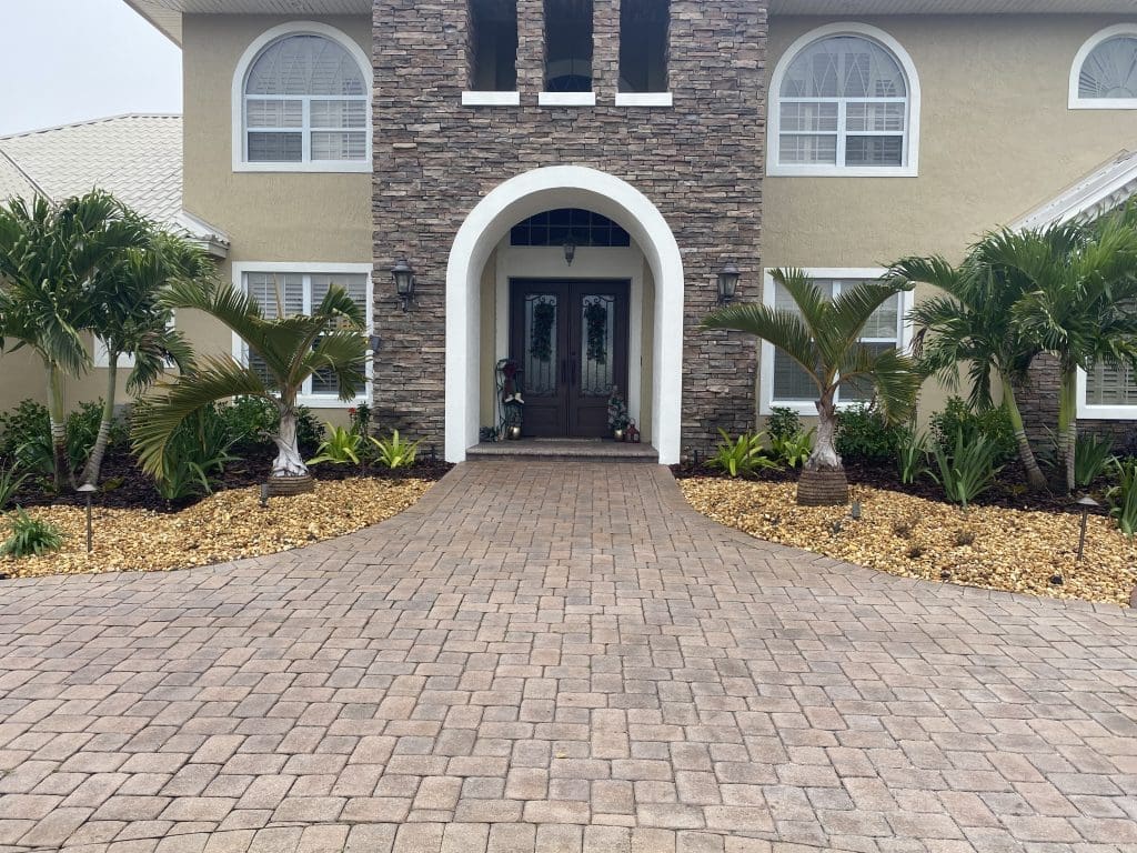 Completed brick-style paver driveway and front entrance at a landscaped Central Florida home